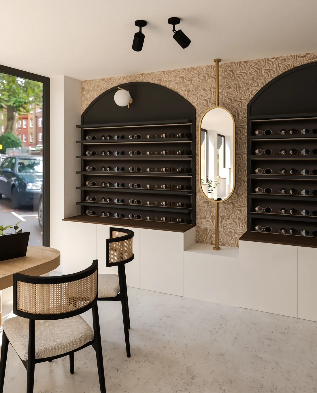 Deux arches murales noires garnies de rangées de montures, miroir étroit entre elles, spots noirs au plafond et chaises d'essayage cannées